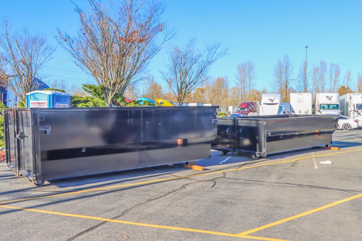 Professional dumpster rental service with roll-off container on residential driveway in Hays